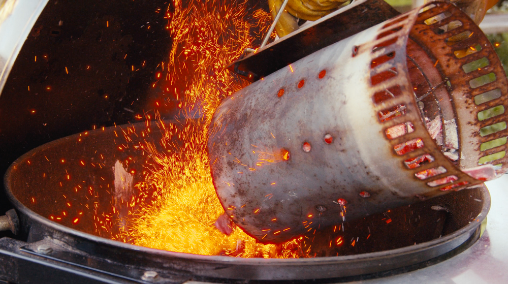 Red-hot charcoal chimney pouring coals