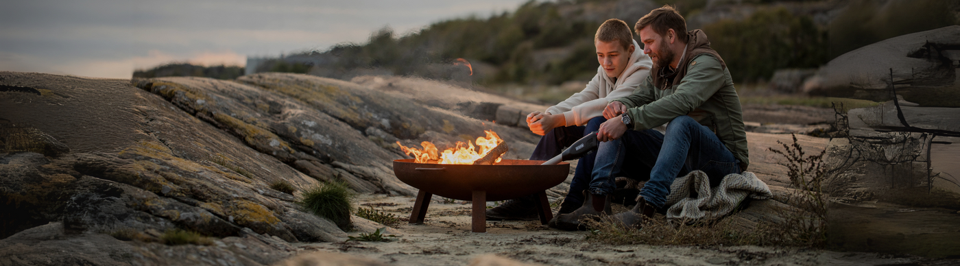 Two people enjoying a campfire in a rocky outdoor setting