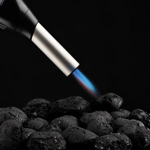 Picture showing an Airlighter barrel pointing at coals with a blue flame.