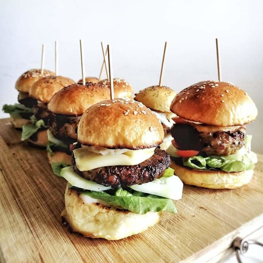 Picture of about 7 burgers with lettuce and cheese