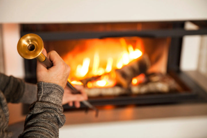 Firedragon fire poker with brass mouthpiece in front of a fireplace