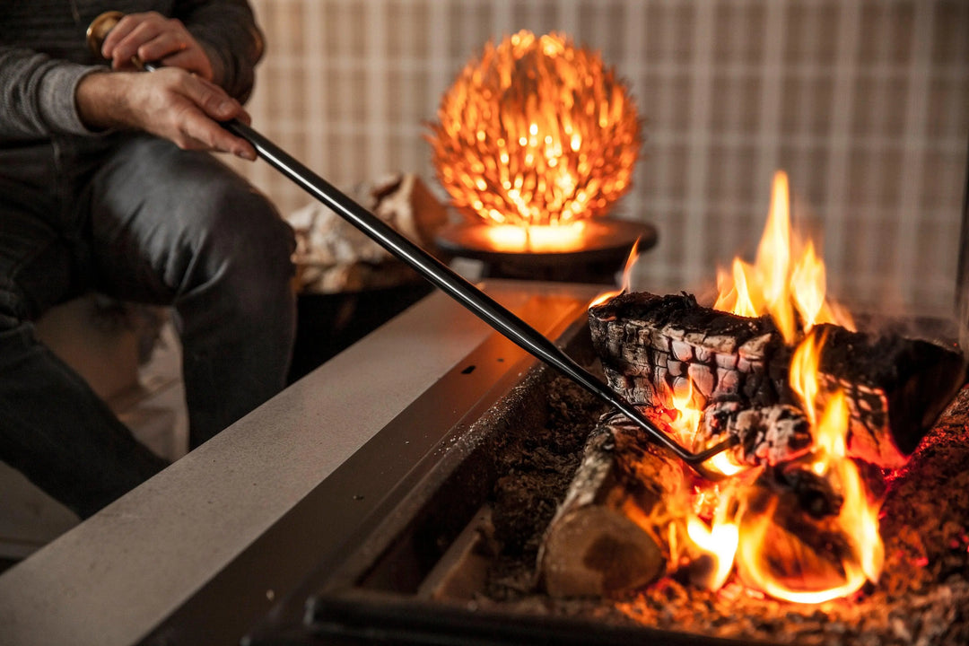 Firedragon fire poker being used to rake coals of a fire