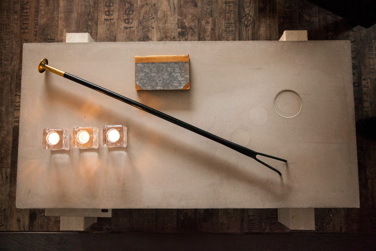 Firedragon fireplace tool beside three lit candles
