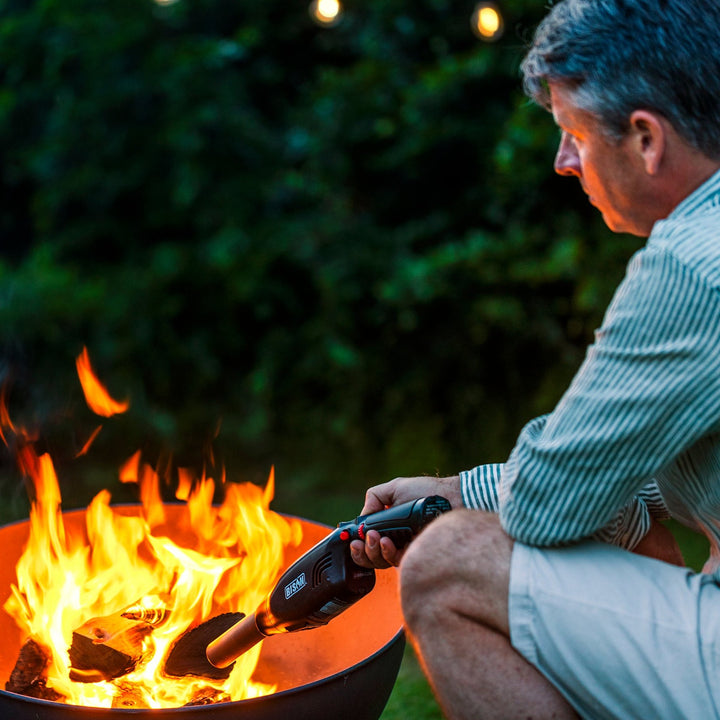 Man lighting a fire pit with an Airlighter